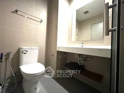 Modern bathroom with sleek fixtures and large mirror in contemporary apartment.