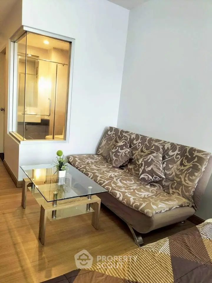 Modern living room with stylish sofa and glass coffee table in cozy apartment.