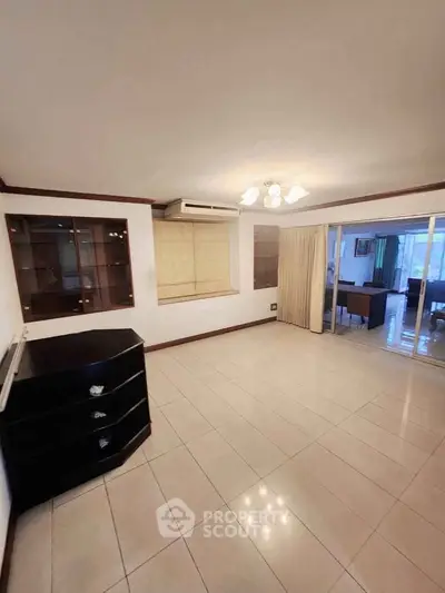 Spacious living room with tiled flooring and built-in shelves, ideal for modern living.