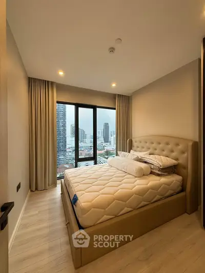 Modern bedroom with city view, featuring a plush bed and floor-to-ceiling windows in a high-rise apartment.