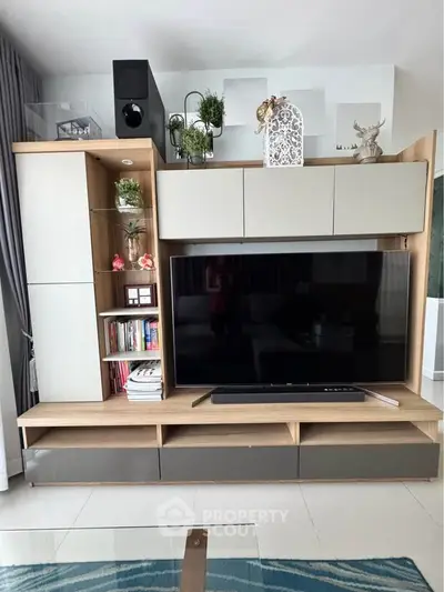 Modern living room with sleek entertainment center and large flat-screen TV, perfect for stylish home entertainment.