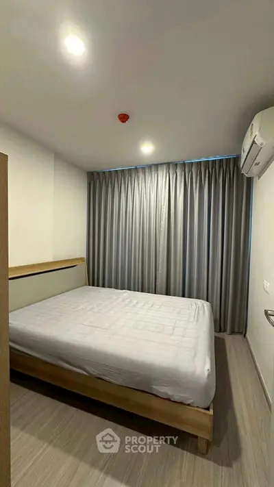 Cozy bedroom with modern decor and ample natural light, featuring a comfortable bed and stylish curtains.