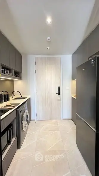 Modern kitchen with sleek appliances and ample storage in a stylish apartment.