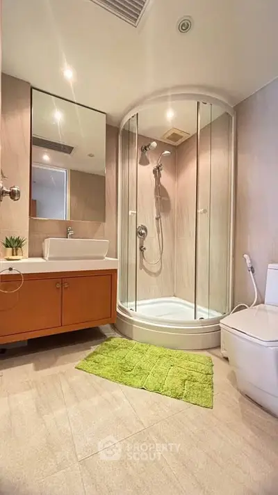 Modern bathroom with glass shower and stylish vanity in a cozy apartment.