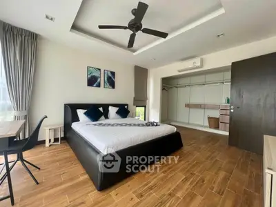 Spacious modern bedroom with wooden flooring and stylish decor