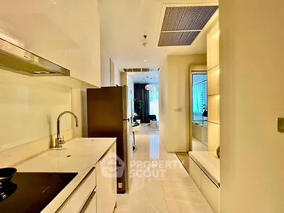 Modern kitchen with sleek design and open layout leading to a bright living area.