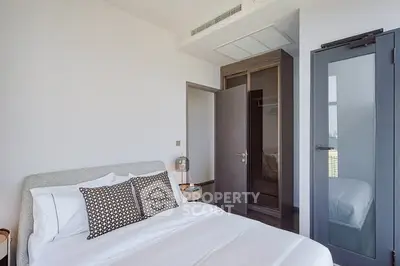 Modern bedroom with sleek design and ample natural light, featuring a comfortable bed and stylish decor.