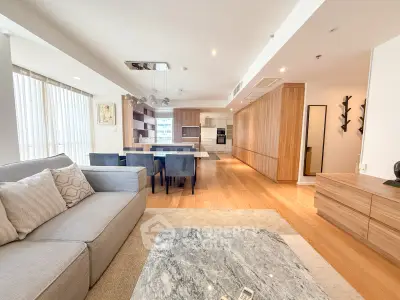 Spacious modern living room with open kitchen and elegant dining area, featuring stylish decor and ample natural light.