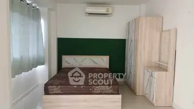Spacious bedroom with modern design and air conditioning, featuring stylish furniture and natural light.