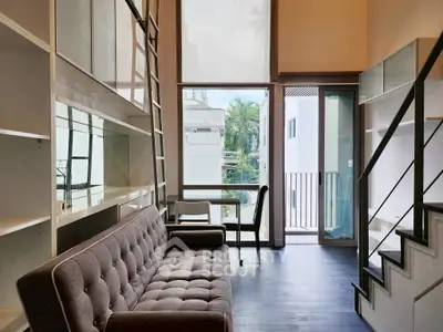 Modern loft-style living room with high ceilings and large windows