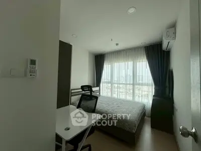 Modern bedroom with large window and stylish furnishings in a high-rise apartment.