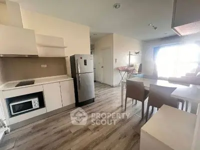 Modern kitchen with dining area, featuring sleek appliances and stylish decor.