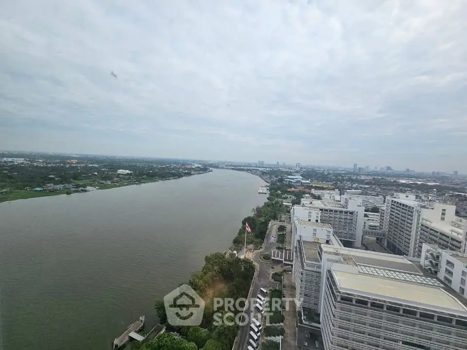 Stunning river view from high-rise building showcasing expansive cityscape and lush greenery.