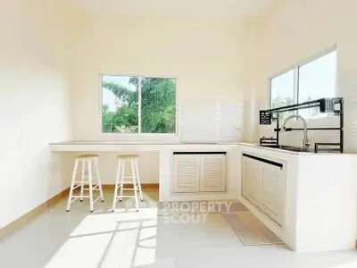 Bright modern kitchen with large windows and sleek white cabinetry