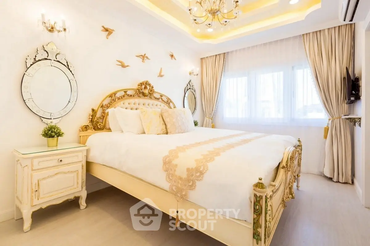 Luxurious bedroom with elegant decor and ornate bed frame, featuring large windows and stylish lighting.