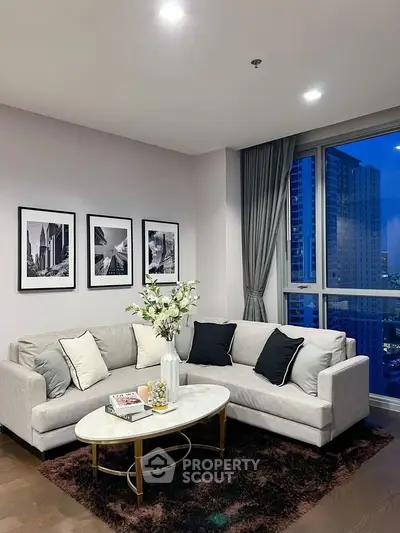 Elegant living room with modern decor and city view, featuring a cozy sofa and stylish coffee table.