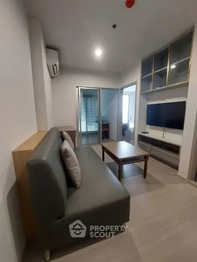 Modern living room with sleek furniture and built-in storage in a cozy apartment.