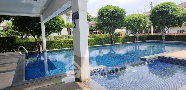 Luxurious outdoor swimming pool with lush greenery and modern design, perfect for relaxation and leisure.