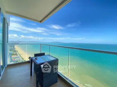 Stunning ocean view from a high-rise balcony with modern outdoor seating.