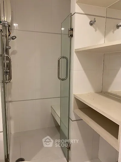 Modern bathroom with glass shower door and built-in shelving