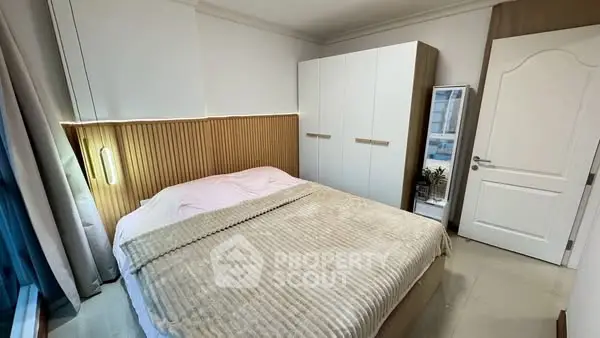 Cozy bedroom with modern wardrobe and elegant lighting, perfect for relaxation.