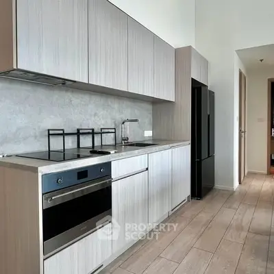 Modern kitchen with sleek cabinetry and built-in oven in a stylish apartment.