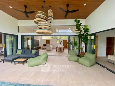 Luxurious open-plan living area with modern decor and poolside view, perfect for relaxation and entertainment.