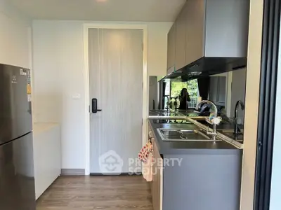 Modern kitchen with sleek cabinetry and stainless steel appliances in a contemporary apartment.