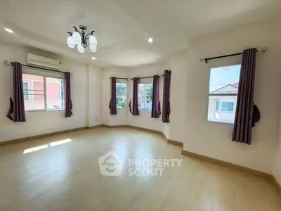 Spacious and bright empty room with large windows and elegant lighting