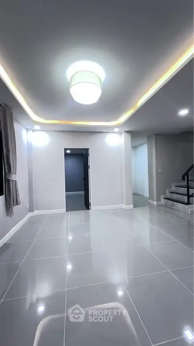 Spacious modern interior with sleek tile flooring and elegant lighting, perfect for contemporary living.