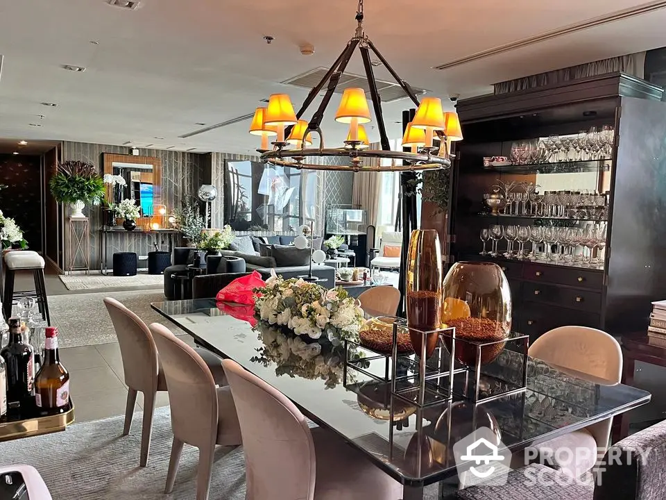 Luxurious dining area with elegant chandelier and stylish decor in modern open-plan living space.