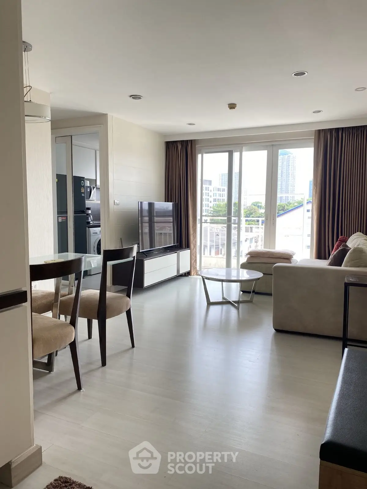 Spacious living room with modern furniture and city view balcony in luxury apartment