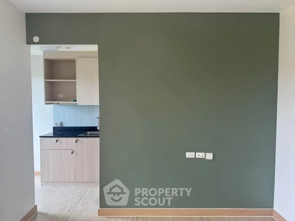 Modern apartment with sleek kitchen and stylish green accent wall, perfect for urban living.