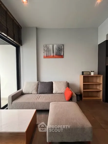Modern living room with stylish sofa and decor, featuring a large window for natural light.