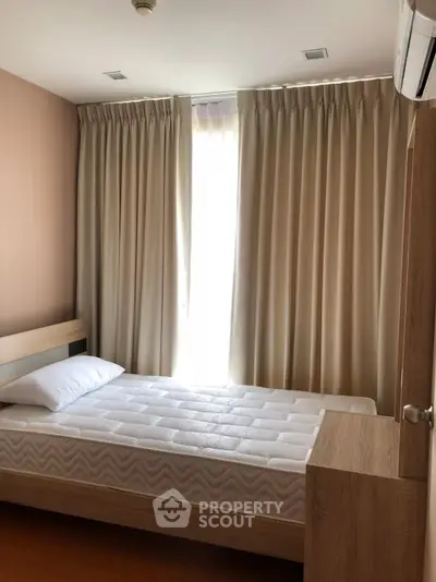 Cozy bedroom with natural light and modern furnishings, perfect for relaxation and comfort.