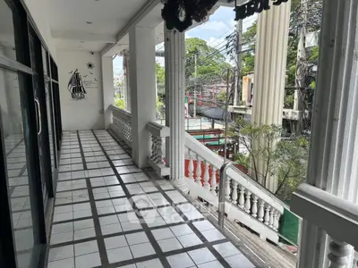 Spacious balcony with tiled flooring and street view, ideal for relaxation or entertaining guests.