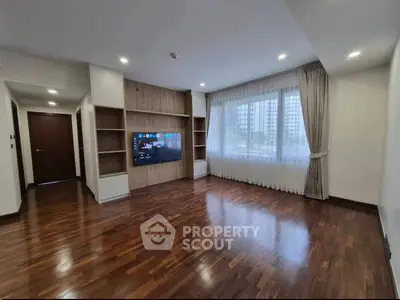 Spacious living room with hardwood floors and built-in entertainment center