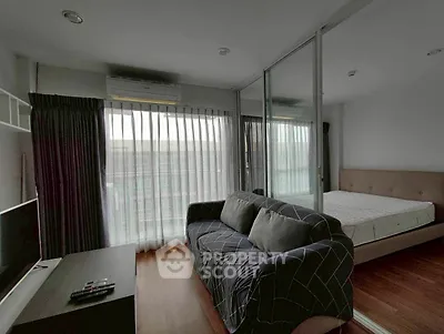 Modern studio apartment with cozy living area and bedroom separated by glass partition.