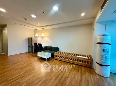 Spacious living room with modern furnishings and wooden flooring in a contemporary apartment.