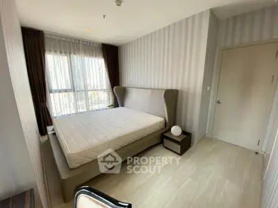 Modern bedroom with large window and stylish decor in a high-rise apartment.