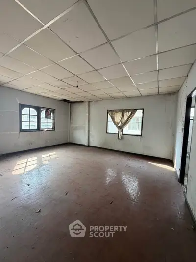 Spacious empty room with large windows and natural light, ideal for customization.