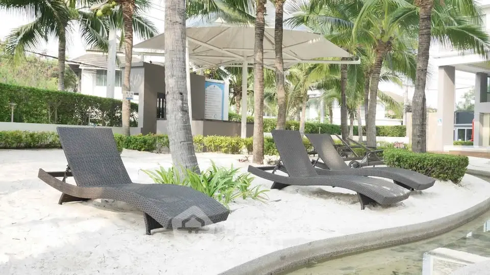 Luxurious poolside area with stylish loungers and lush greenery, perfect for relaxation.