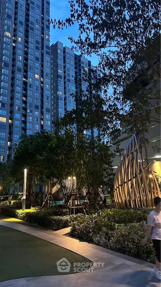 Stunning evening view of modern high-rise buildings with lush landscaped gardens and unique architectural features.