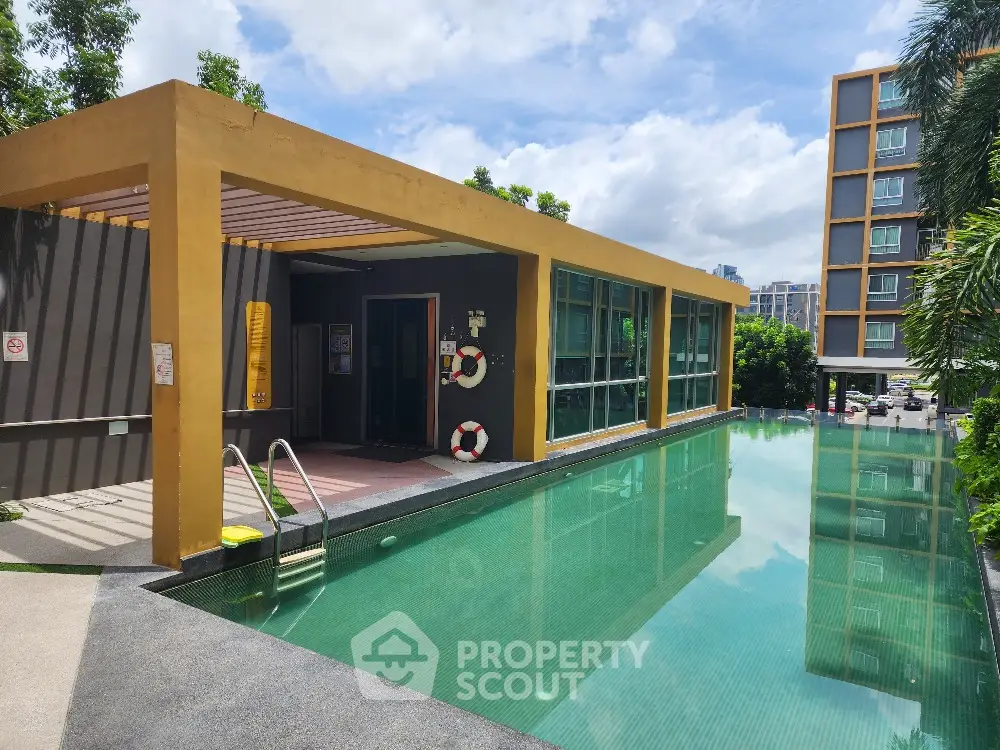 Inviting poolside area with modern amenities and lush greenery, perfect for relaxation and entertainment in a luxury residential complex.