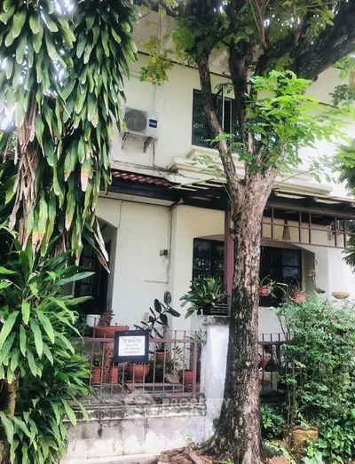 Charming two-story house with lush greenery and inviting entrance