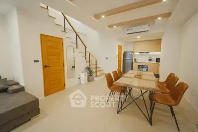 Modern open-plan living and dining area with stylish kitchen and staircase.