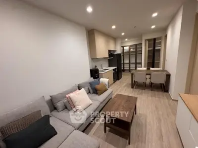Modern living room with open kitchen and stylish furniture in a cozy apartment.