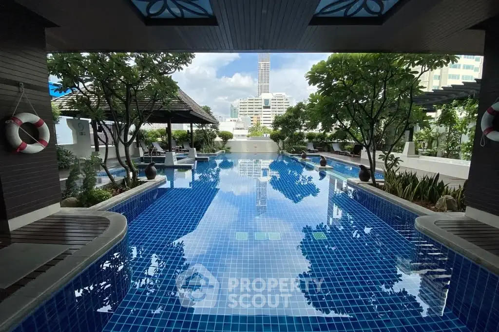 Luxurious rooftop pool with stunning city views and lush greenery, perfect for relaxation and leisure.