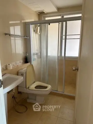 Compact bathroom with shower and toilet in a cozy real estate property.