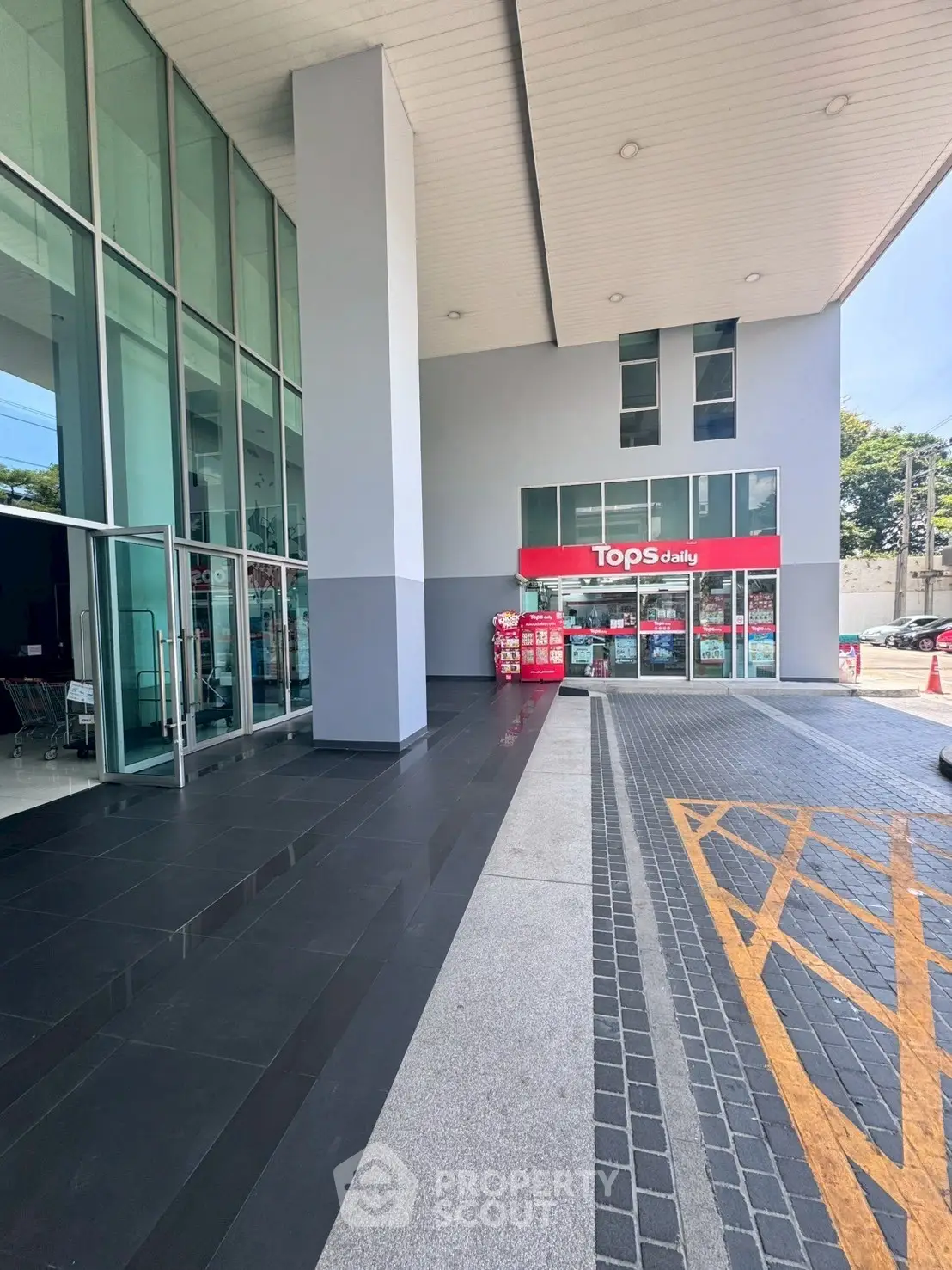 Modern commercial building entrance with glass facade and retail store